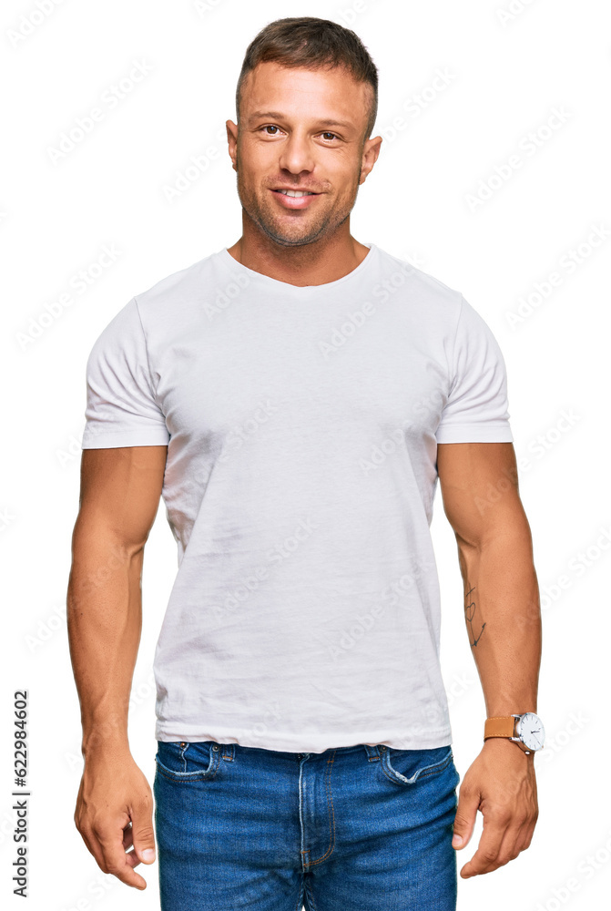 Handsome muscle man wearing casual white tshirt with a happy and cool smile on face. lucky person. Handsome muscle man wearing casual white tshirt with a happy and cool smile on face. lucky person.