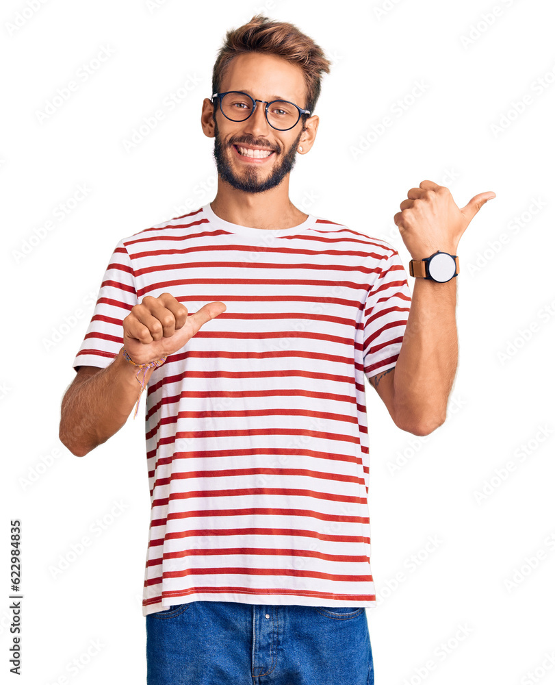 Handsome blond man with beard wearing casual clothes and glasses pointing to the back behind with hand and thumbs up, smiling confident Handsome blond man with beard wearing casual clothes and glasses pointing to the back behind with hand and thumbs up, smiling confident
