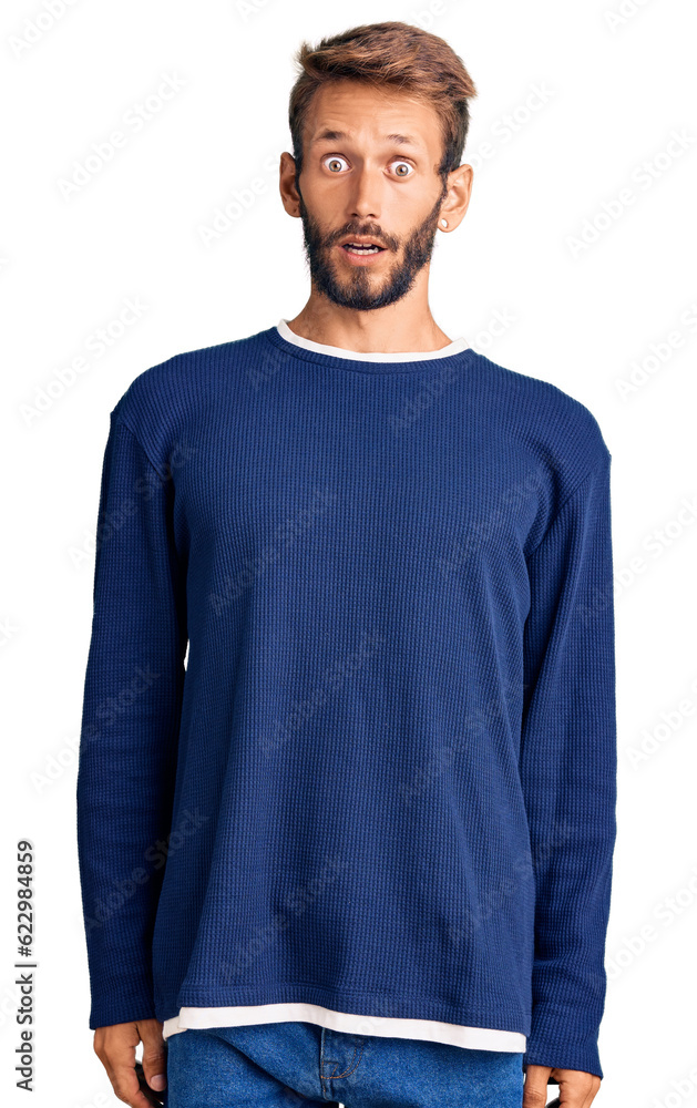 Handsome blond man with beard wearing casual sweater afraid and shocked with surprise and amazed expression, fear and excited face. Handsome blond man with beard wearing casual sweater afraid and shocked with surprise and amazed expression, fear and excited face.