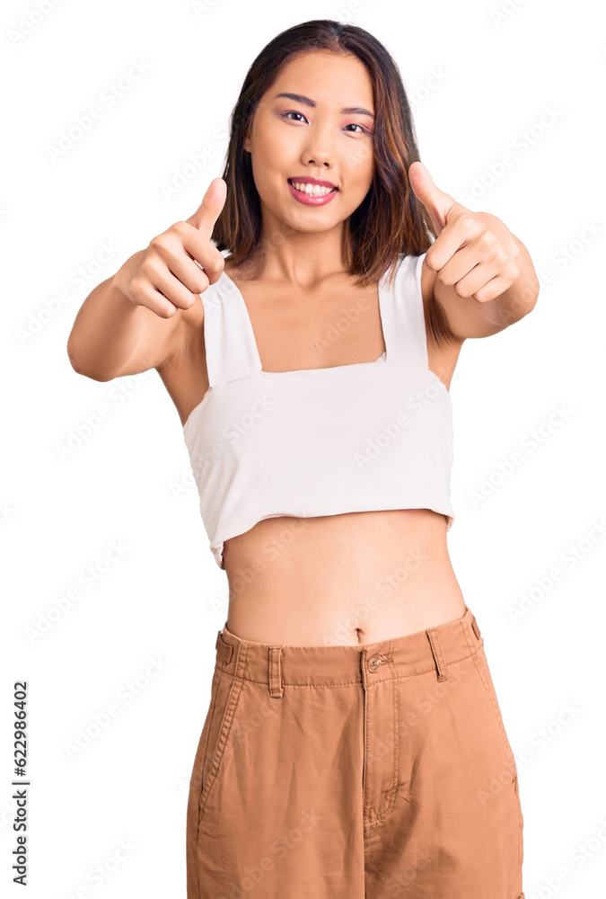 Young beautiful chinese girl wearing casual clothes approving doing positive gesture with hand, thumbs up smiling and happy for success. winner gesture. Young beautiful chinese girl wearing casual clothes approving doing positive gesture with hand, thumbs up smiling and happy for success. winner gesture.