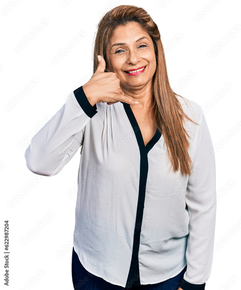 Middle age latin woman wearing business shirt smiling doing phone gesture with hand and fingers like talking on the telephone. communicating concepts. Middle age latin woman wearing business shirt smiling doing phone gesture with hand and fingers like talking on the telephone. communicating concepts.