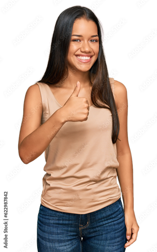 Obraz premium Beautiful hispanic woman wearing casual clothes doing happy thumbs up gesture with hand. approving expression looking at the camera showing success.