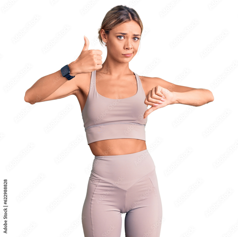 Beautiful caucasian woman wearing sportswear doing thumbs up and down, disagreement and agreement expression. crazy conflict Beautiful caucasian woman wearing sportswear doing thumbs up and down, disagreement and agreement expression. crazy conflict