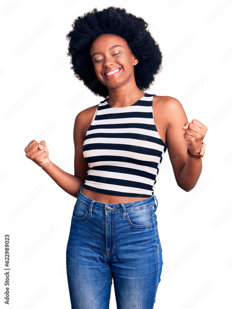 Young african american woman wearing casual clothes very happy and excited doing winner gesture with arms raised, smiling and screaming for success. celebration concept. Young african american woman wearing casual clothes very happy and excited doing winner gesture with arms raised, smiling and screaming for success. celebration concept.