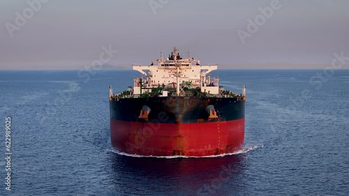 Aerial front view of a heavy crude oil tanker traveling over calm sea during sunset photo