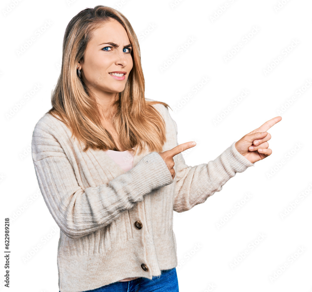 Young blonde woman wearing casual clothes pointing aside worried and nervous with both hands, concerned and surprised expression Young blonde woman wearing casual clothes pointing aside worried and nervous with both hands, concerned and surprised expression