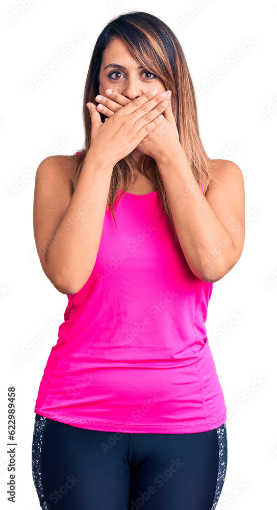 Young beautiful woman wearing sportswear shocked covering mouth with hands for mistake. secret concept. Young beautiful woman wearing sportswear shocked covering mouth with hands for mistake. secret concept.