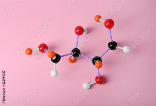Molecule of sugar on pink background, top view. Chemical model