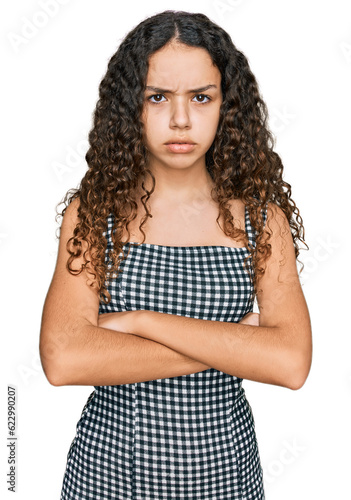 Teenager hispanic girl wearing casual clothes skeptic and nervous, disapproving expression on face with crossed arms. negative person.