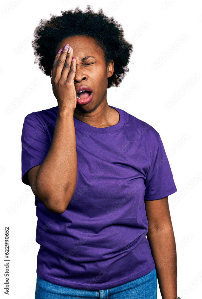 African american woman with afro hair wearing casual purple t shirt yawning tired covering half face, eye and mouth with hand. face hurts in pain.