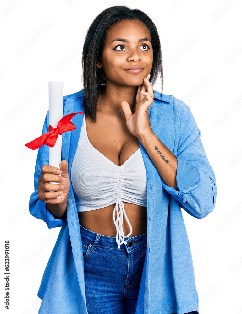 Beautiful hispanic woman holding graduate degree diploma serious face thinking about question with hand on chin, thoughtful about confusing idea Beautiful hispanic woman holding graduate degree diploma serious face thinking about question with hand on chin, thoughtful about confusing idea