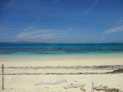 Fototapeta Naklejka Na Ścianę i Meble -  Beautiful White Sand Beach Located in North Maluku, Indonesia. Beautiful Scenery of Blue Sky, Ocean and White Sand Beach.