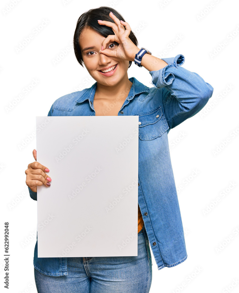 Beautiful young woman with short hair holding blank empty banner smiling happy doing ok sign with hand on eye looking through fingers Beautiful young woman with short hair holding blank empty banner smiling happy doing ok sign with hand on eye looking through fingers