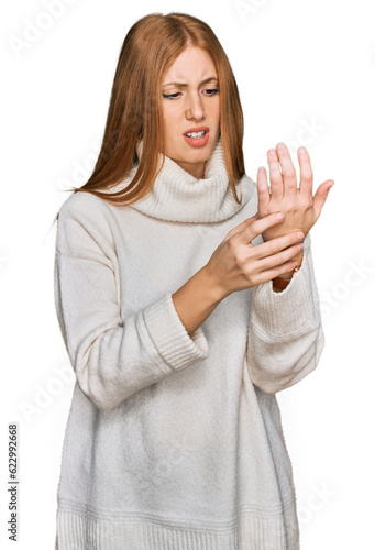 Young irish woman wearing casual winter sweater suffering pain on hands and fingers, arthritis inflammation