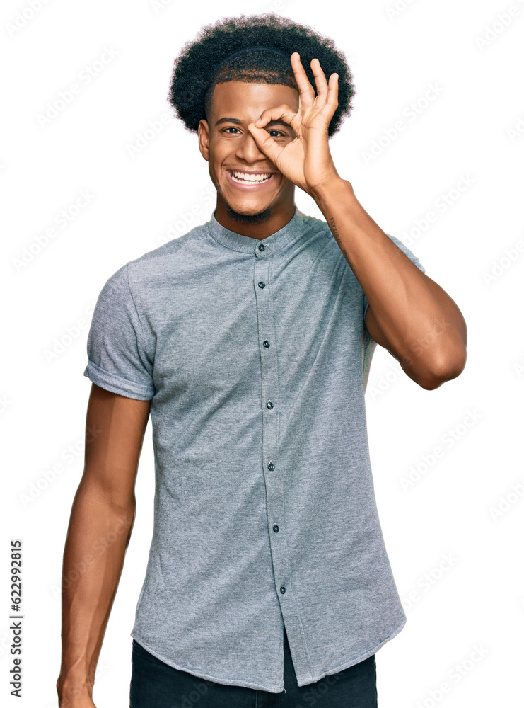 African american man with afro hair wearing casual clothes doing ok gesture with hand smiling, eye looking through fingers with happy face. African american man with afro hair wearing casual clothes doing ok gesture with hand smiling, eye looking through fingers with happy face.