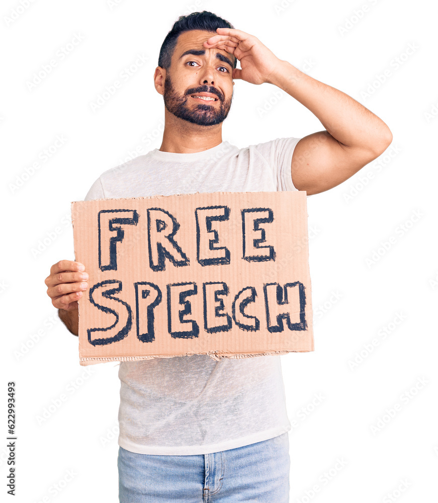 Young hispanic man holding free speech banner stressed and frustrated with hand on head, surprised and angry face Young hispanic man holding free speech banner stressed and frustrated with hand on head, surprised and angry face