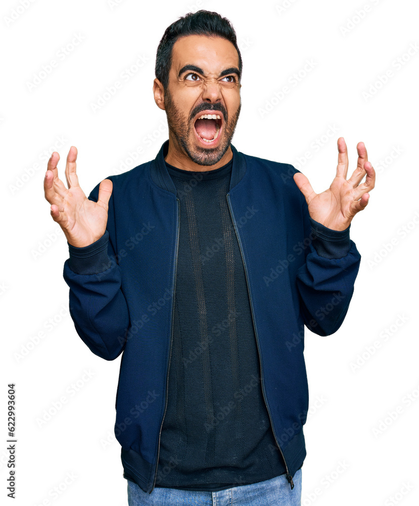 Fototapeta premium Young hispanic man wearing casual clothes crazy and mad shouting and yelling with aggressive expression and arms raised. frustration concept.