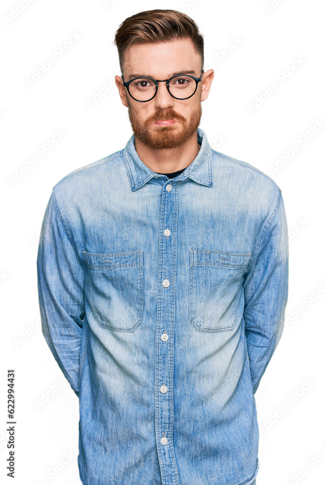 Young redhead man wearing casual denim shirt depressed and worry for distress, crying angry and afraid. sad expression. Young redhead man wearing casual denim shirt depressed and worry for distress, crying angry and afraid. sad expression.