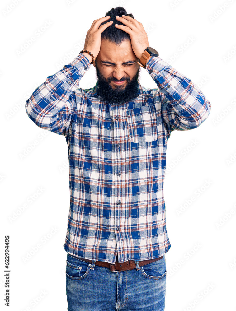 Fototapeta premium Young arab man wearing casual clothes suffering from headache desperate and stressed because pain and migraine. hands on head.