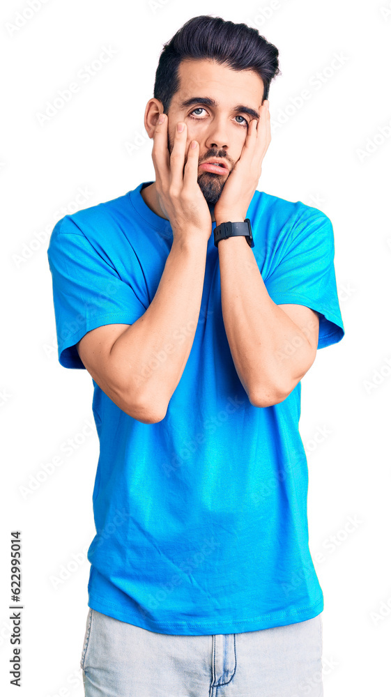 Young handsome man with beard wearing casual t-shirt tired hands covering face, depression and sadness, upset and irritated for problem Young handsome man with beard wearing casual t-shirt tired hands covering face, depression and sadness, upset and irritated for problem