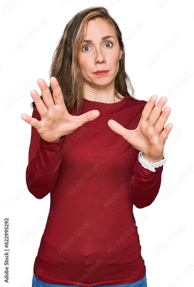 Young blonde woman wearing casual clothes afraid and terrified with fear expression stop gesture with hands, shouting in shock. panic concept. Young blonde woman wearing casual clothes afraid and terrified with fear expression stop gesture with hands, shouting in shock. panic concept.