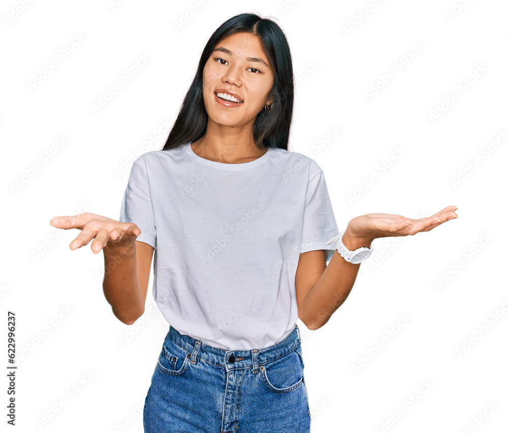 Beautiful young asian woman wearing casual white t shirt smiling cheerful offering hands giving assistance and acceptance. Beautiful young asian woman wearing casual white t shirt smiling cheerful offering hands giving assistance and acceptance.