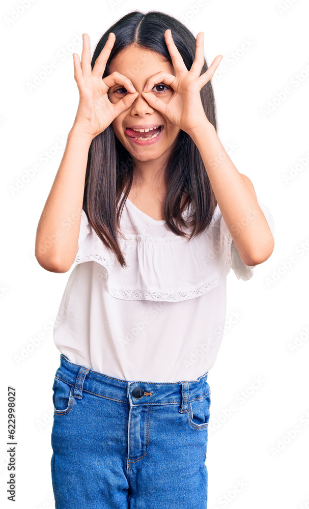 Beautiful child girl wearing casual clothes doing ok gesture like binoculars sticking tongue out, eyes looking through fingers. crazy expression. Beautiful child girl wearing casual clothes doing ok gesture like binoculars sticking tongue out, eyes looking through fingers. crazy expression.