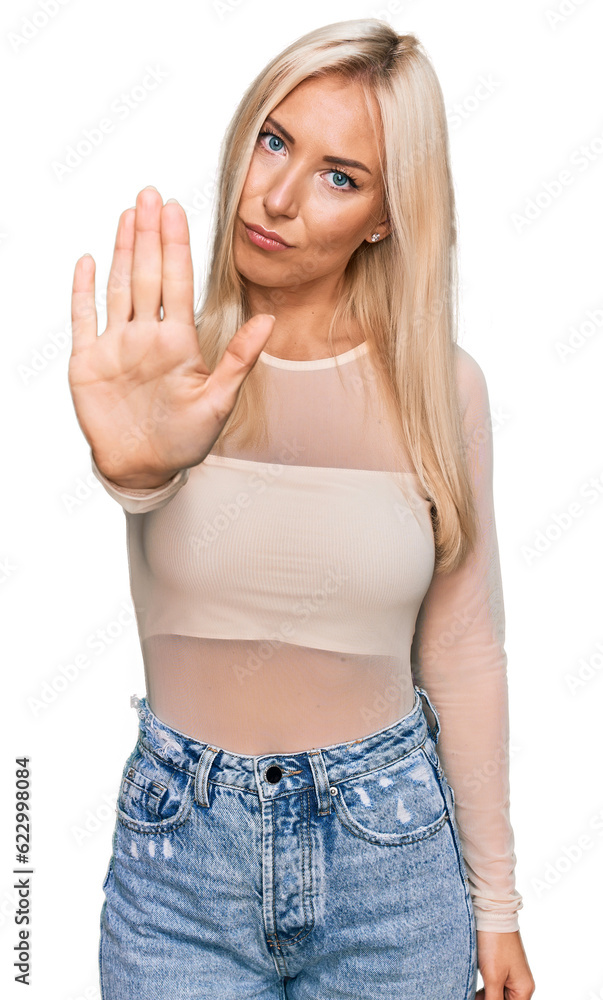 Young blonde woman wearing casual clothes doing stop sing with palm of the hand. warning expression with negative and serious gesture on the face. Young blonde woman wearing casual clothes doing stop sing with palm of the hand. warning expression with negative and serious gesture on the face.