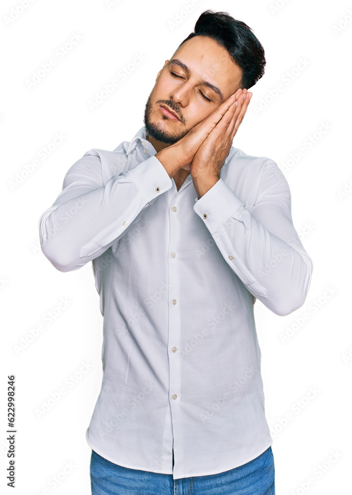 Young arab man wearing casual clothes sleeping tired dreaming and posing with hands together while smiling with closed eyes. Young arab man wearing casual clothes sleeping tired dreaming and posing with hands together while smiling with closed eyes.