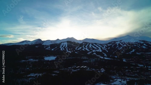 Stunning pan to the right slow Breckenridge ten mile peak Colorado ski trails during sunset mid epic pass orange yellow bright clouds shaded mountain peak 8 9 10 cold family vacation Rocky Mountains photo