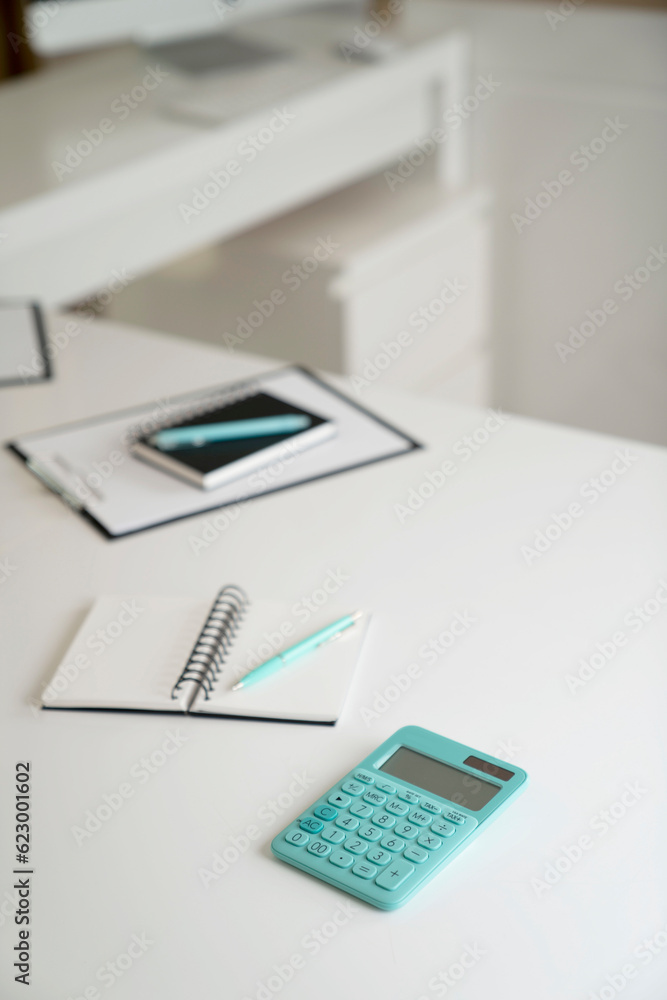 Workplace in the office. Notebook, computer, mobil phone and calculator on the white shining desk. Workplace in the office. Notebook, computer, mobil phone and calculator on the white shining desk.