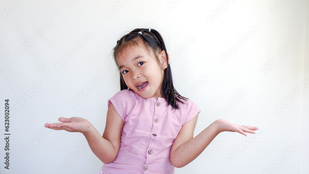 Beautiful smiling happy little asian girl in pink shirt. Charming female child open hands palm up holding something on isolated white background. Adorable pretty child and copy space. Beautiful smiling happy little asian girl in pink shirt. Charming female child open hands palm up holding something on isolated white background. Adorable pretty child and copy space.