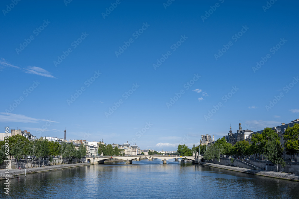 Beautiful panoramic view from the Seine River to the bridge and the city landscape on a sunny summer day. Paris, France.