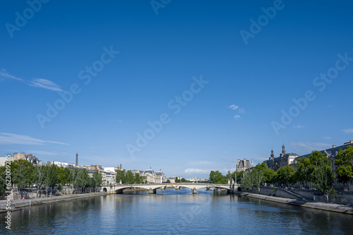 Beautiful panoramic view from the Seine River to the bridge and the city landscape on a sunny summer day. Paris, France. © B. Van