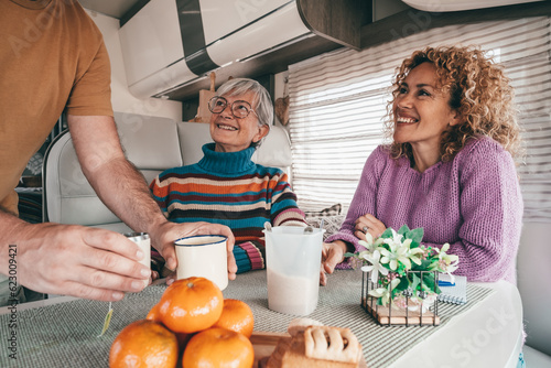 Group of bonding family people enjoy stay together inside a camper van motor home at the coffee break. Smiling people enjoying free lifestyle, vacation, freedom journey modern people concept photo