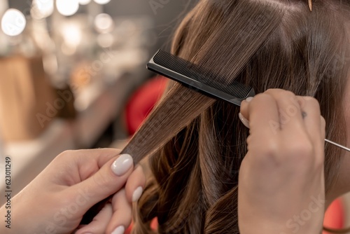 hairdresser coiffeur makes hairstyle Closeup