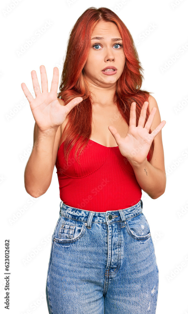 Young redhead woman wearing casual clothes afraid and terrified with fear expression stop gesture with hands, shouting in shock. panic concept. Young redhead woman wearing casual clothes afraid and terrified with fear expression stop gesture with hands, shouting in shock. panic concept.