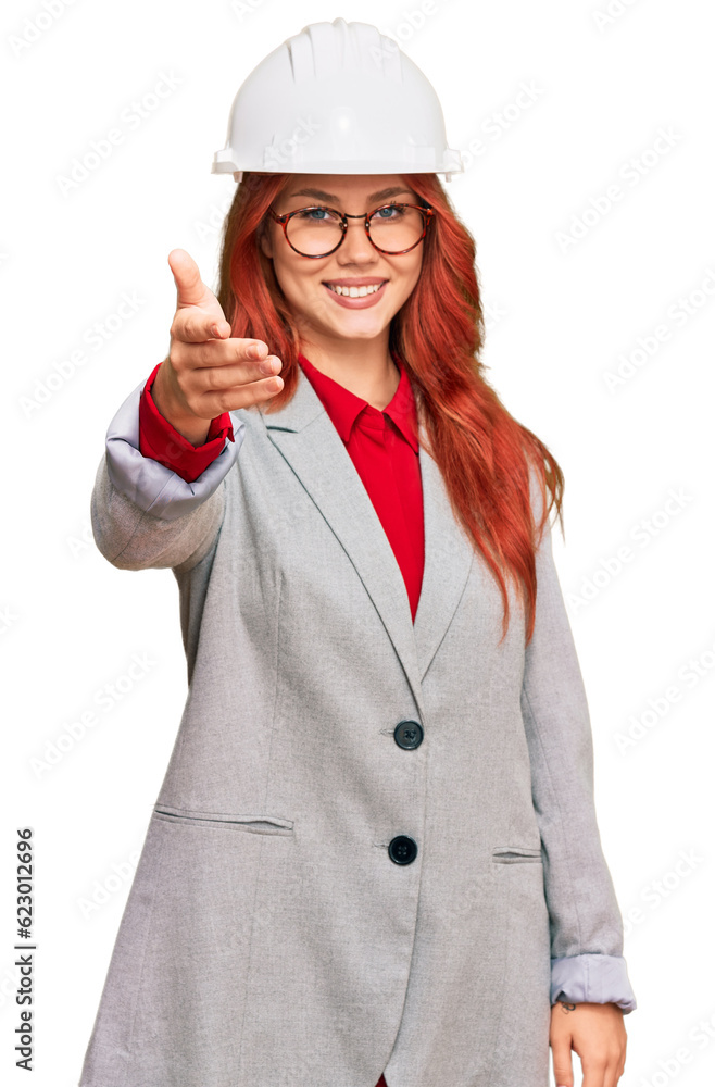 Young redhead woman wearing architect hardhat smiling friendly offering handshake as greeting and welcoming. successful business. Young redhead woman wearing architect hardhat smiling friendly offering handshake as greeting and welcoming. successful business.