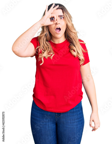 Young caucasian woman wearing casual clothes doing ok gesture shocked with surprised face, eye looking through fingers. unbelieving expression.