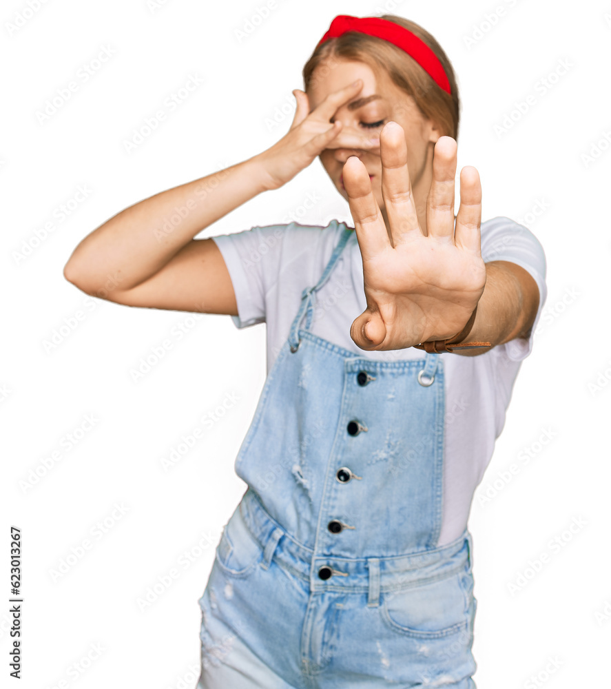 Young caucasian girl wearing casual clothes covering eyes with hands and doing stop gesture with sad and fear expression. embarrassed and negative concept. Young caucasian girl wearing casual clothes covering eyes with hands and doing stop gesture with sad and fear expression. embarrassed and negative concept.