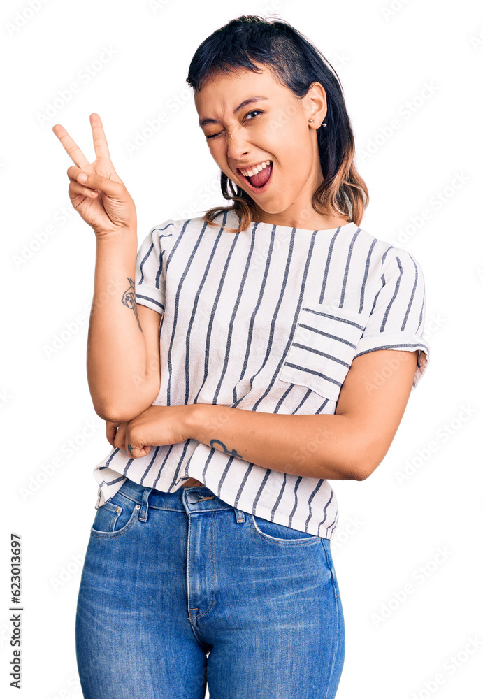 Young woman wearing casual clothes smiling with happy face winking at the camera doing victory sign with fingers. number two. Young woman wearing casual clothes smiling with happy face winking at the camera doing victory sign with fingers. number two.