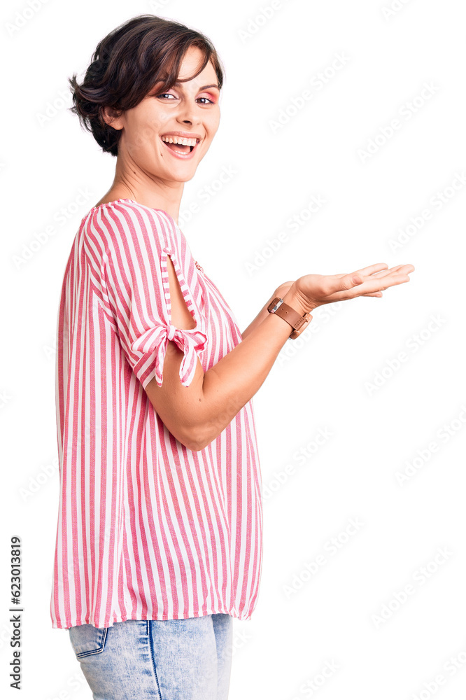 Beautiful young woman with short hair wearing casual summer clothes pointing aside with hands open palms showing copy space, presenting advertisement smiling excited happy Beautiful young woman with short hair wearing casual summer clothes pointing aside with hands open palms showing copy space, presenting advertisement smiling excited happy