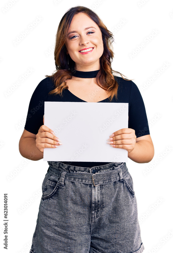 Young beautiful caucasian woman holding blank empty paper looking positive and happy standing and smiling with a confident smile showing teeth Young beautiful caucasian woman holding blank empty paper looking positive and happy standing and smiling with a confident smile showing teeth