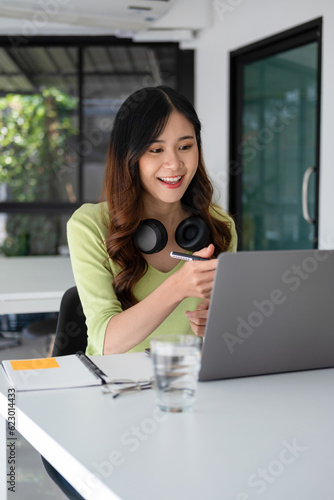 Young woman engaged in online study, video call, project work.