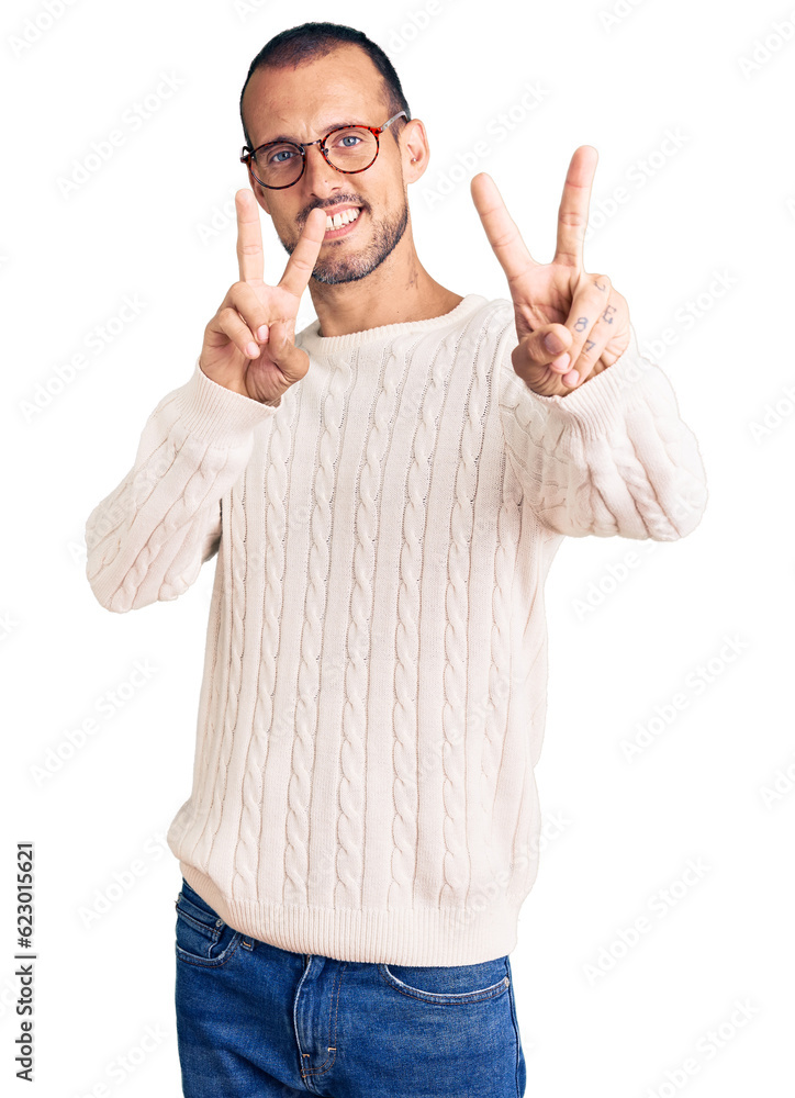 Young handsome man wearing casual clothes and glasses smiling looking to the camera showing fingers doing victory sign. number two. Young handsome man wearing casual clothes and glasses smiling looking to the camera showing fingers doing victory sign. number two.