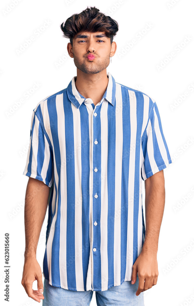 Young hispanic man wearing casual clothes puffing cheeks with funny face. mouth inflated with air, crazy expression. Young hispanic man wearing casual clothes puffing cheeks with funny face. mouth inflated with air, crazy expression.