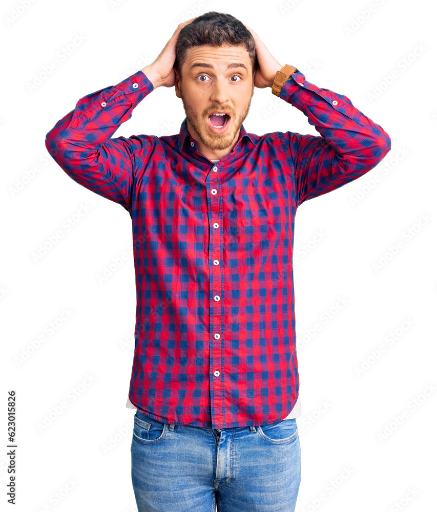 Fototapeta premium Handsome young man with bear wearing casual shirt crazy and scared with hands on head, afraid and surprised of shock with open mouth