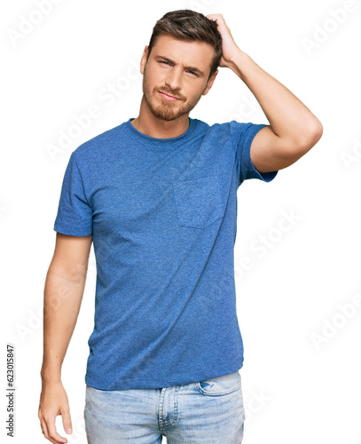 Handsome caucasian man wearing casual clothes confuse and wonder about question. uncertain with doubt, thinking with hand on head. pensive concept.