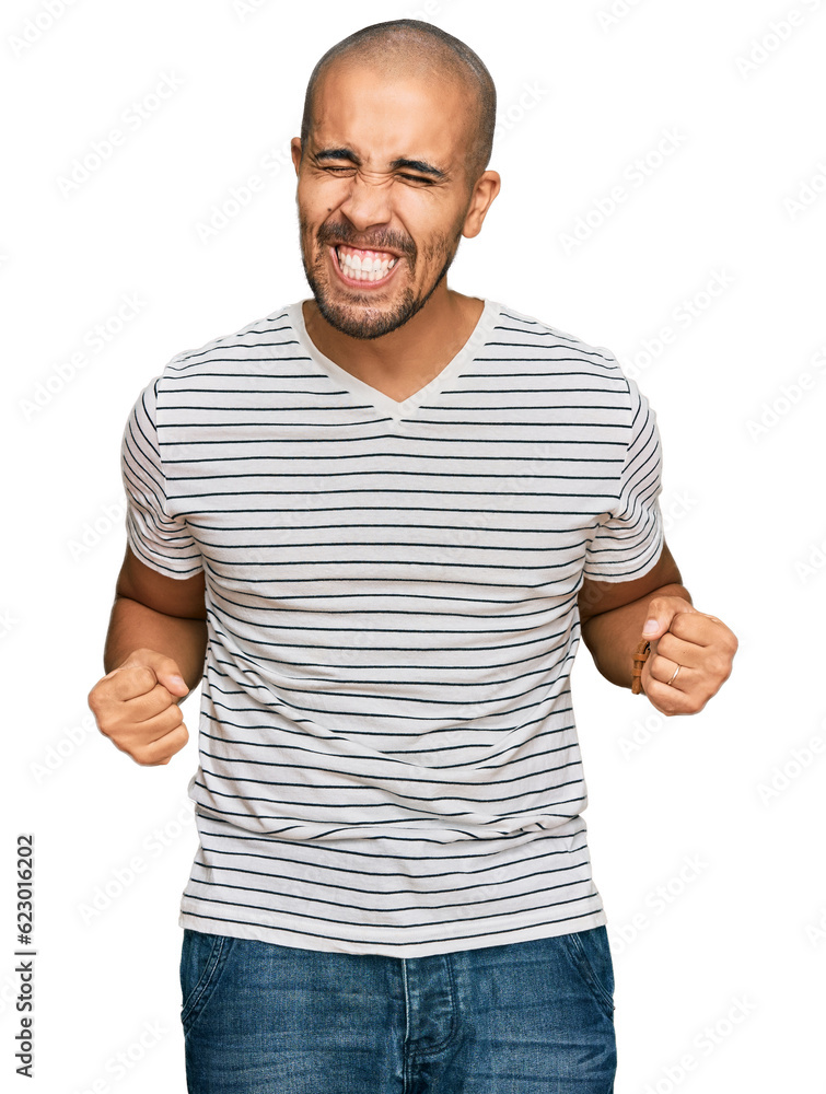 Hispanic adult man wearing casual clothes very happy and excited doing winner gesture with arms raised, smiling and screaming for success. celebration concept. Hispanic adult man wearing casual clothes very happy and excited doing winner gesture with arms raised, smiling and screaming for success. celebration concept.