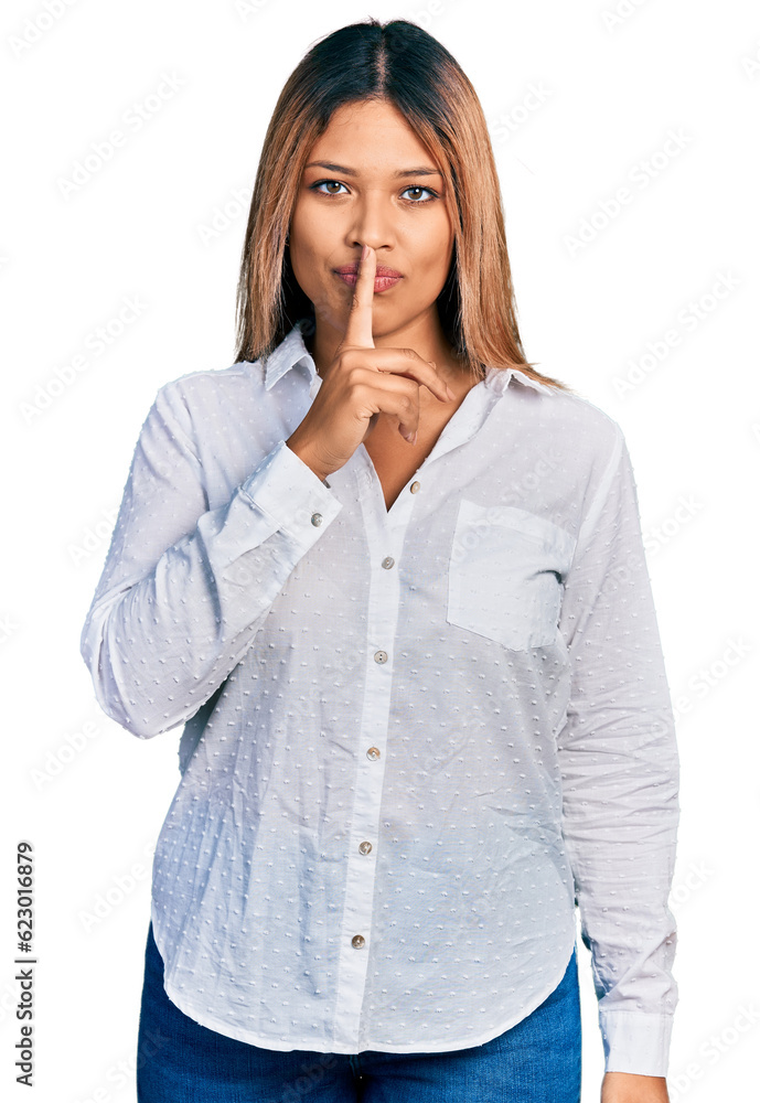 Young hispanic woman wearing casual white shirt asking to be quiet with finger on lips. silence and secret concept. Young hispanic woman wearing casual white shirt asking to be quiet with finger on lips. silence and secret concept.